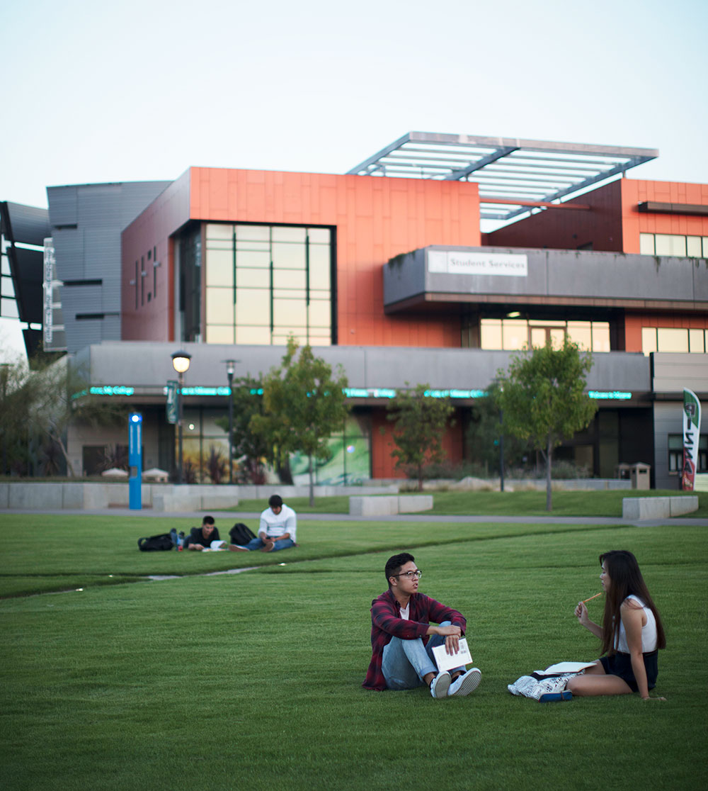 two students sit on the grass at miramar college