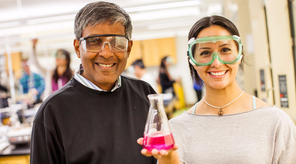 a chemistry professor and student hold a flask