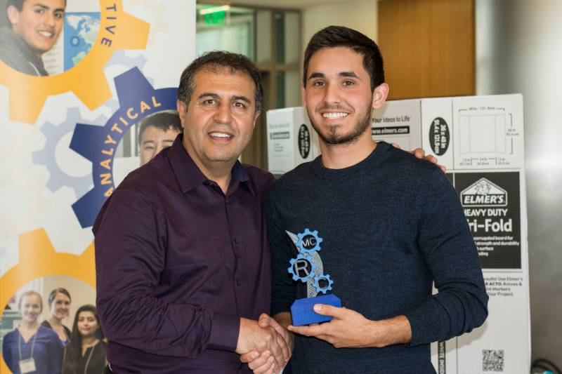 A student is given an award during the Mesa College Research Conference (MCRC), an event that showcases research-based presentations.