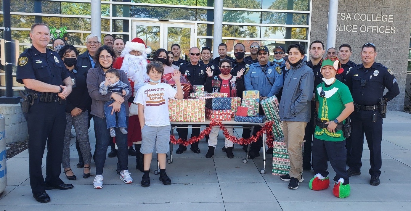 Officers and the sponsored family surrounded by gifts