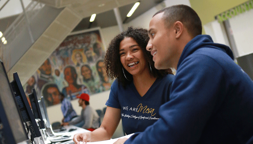 Two students look at a computer