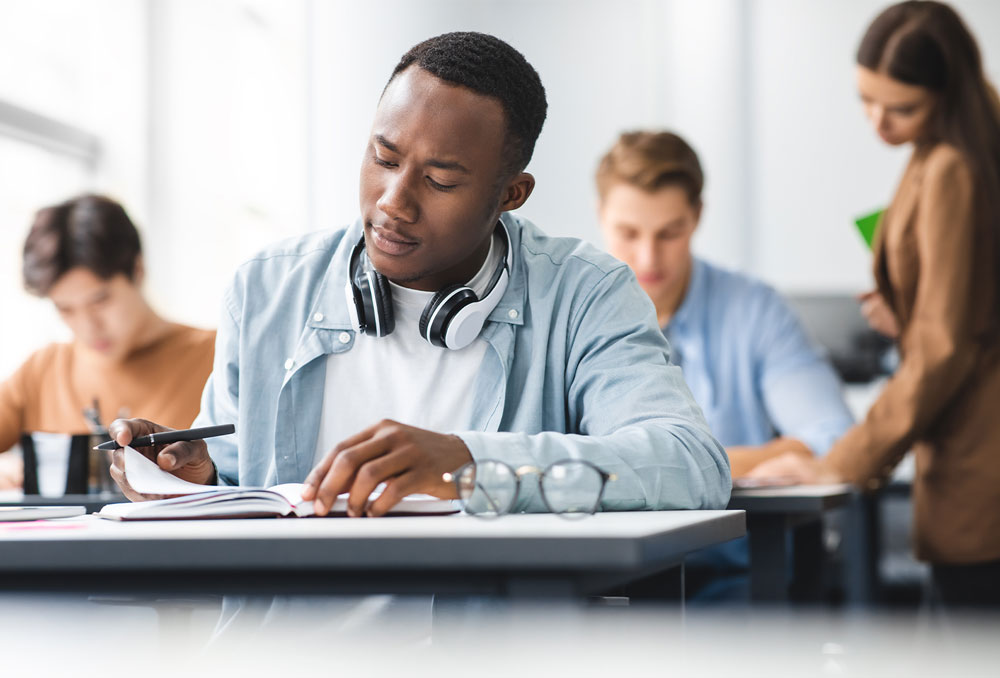 A student at a table looking at a notebook