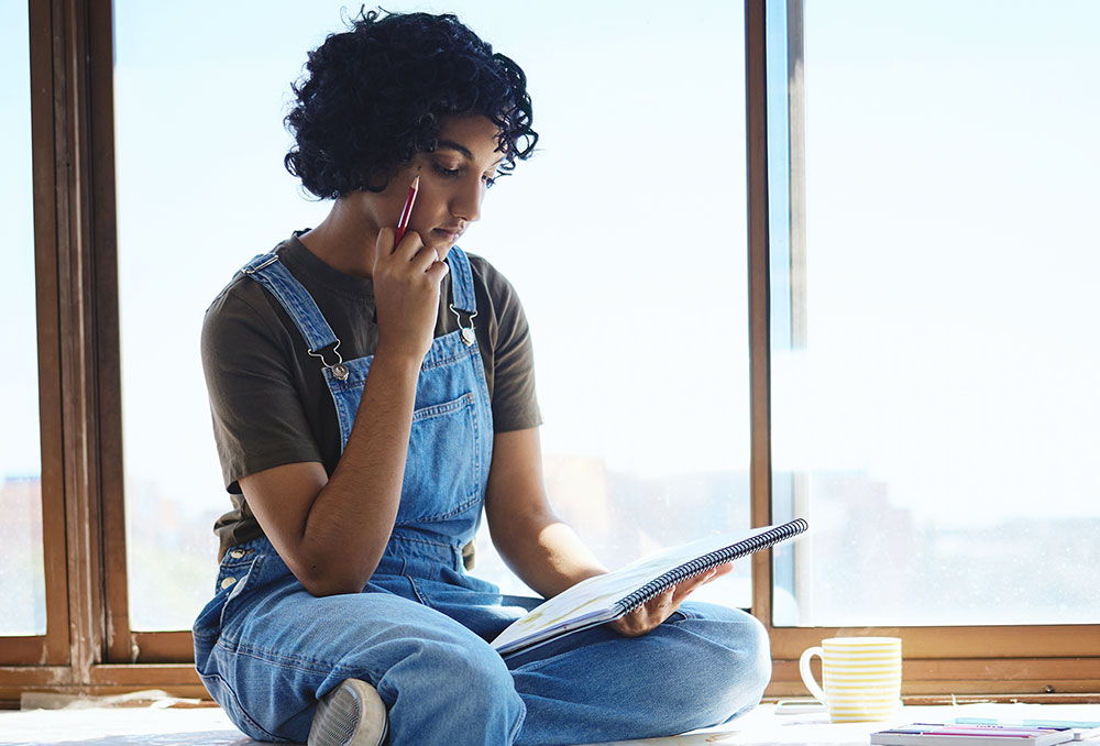 A student seated looking down at a piece of paper