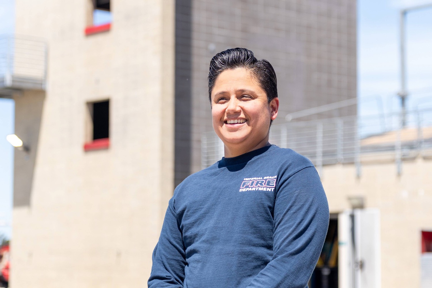 Public safety management student Erika Trello stands in front of the tower used as a fire training building at Miramar College.