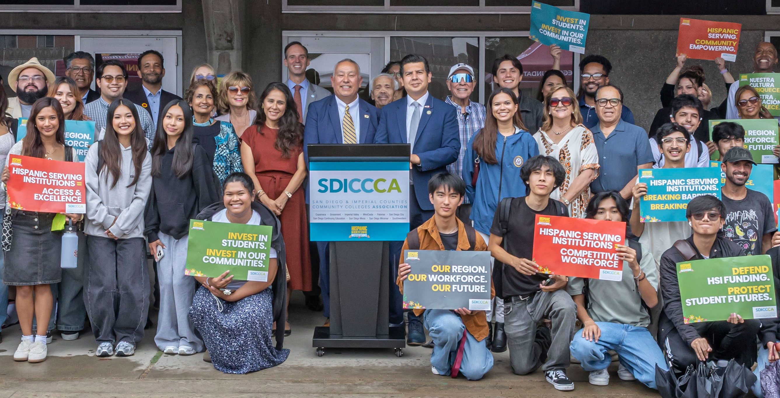 Area leaders and students with green and orange signs supporting HSI's at the news conference