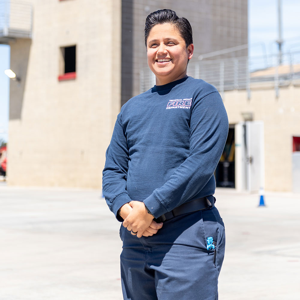 Erika Tello standing near the tower where fire training is conducted at Miramar
