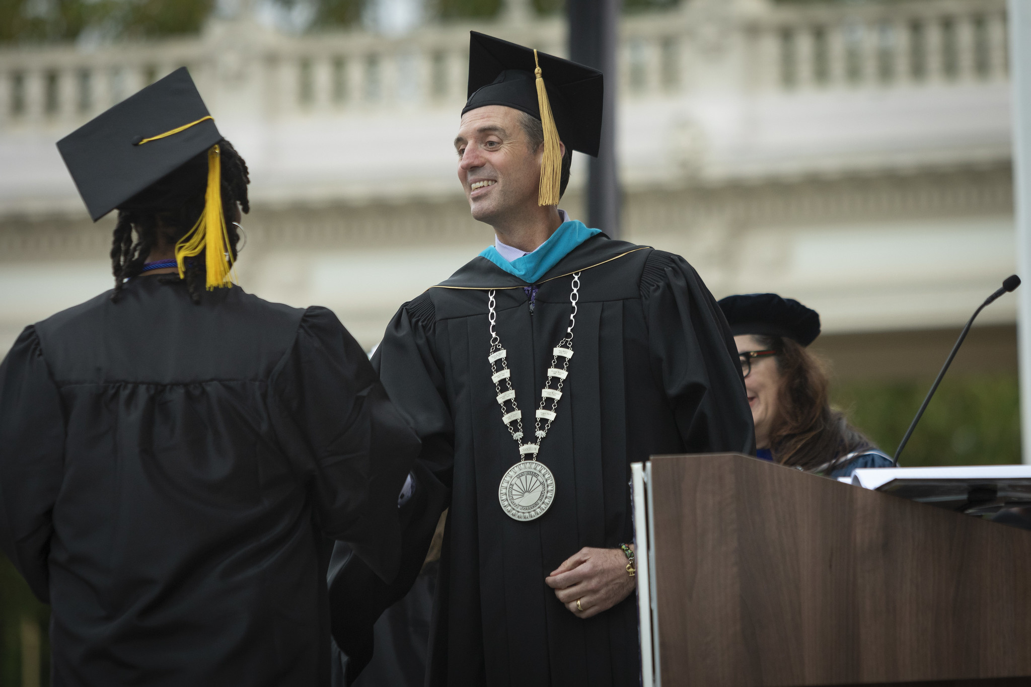 
Chancellor Gregory Smith on stage shaking a graduate's hand.
