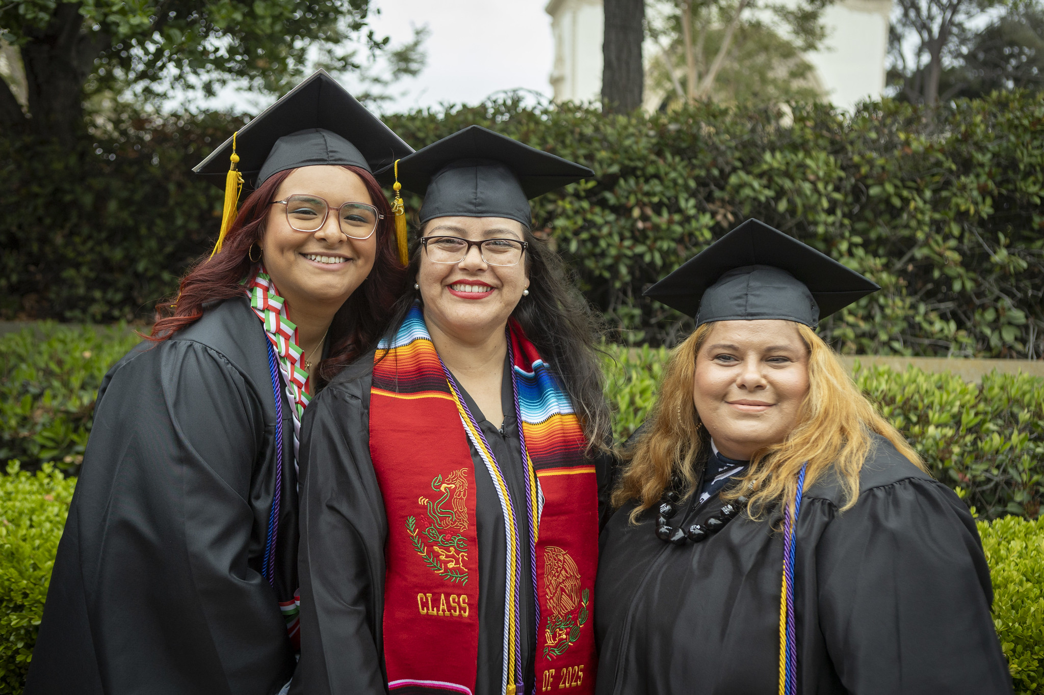 
Three friends take a group photo in their graduation caps and gowns.
