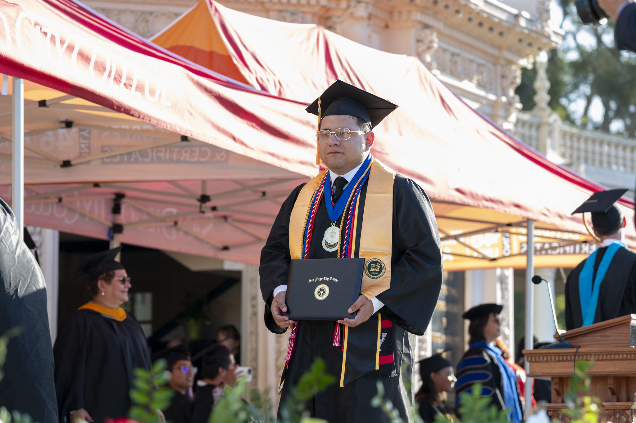 
A graduate walks across the stage with his degree.
