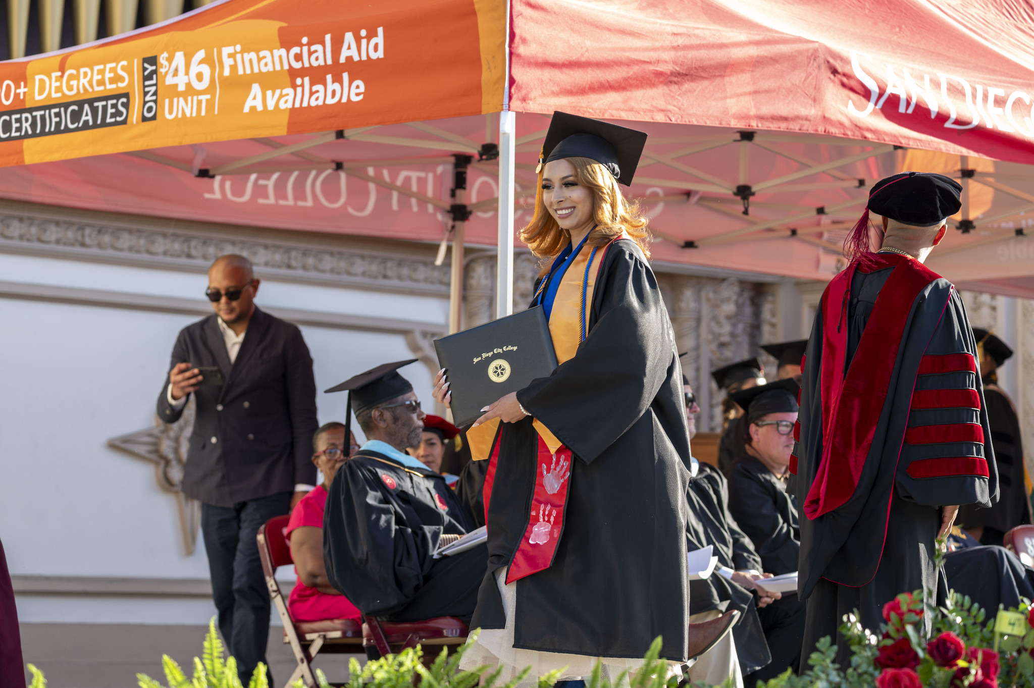 
A students pauses on stage for a photo after receiving her degree.
