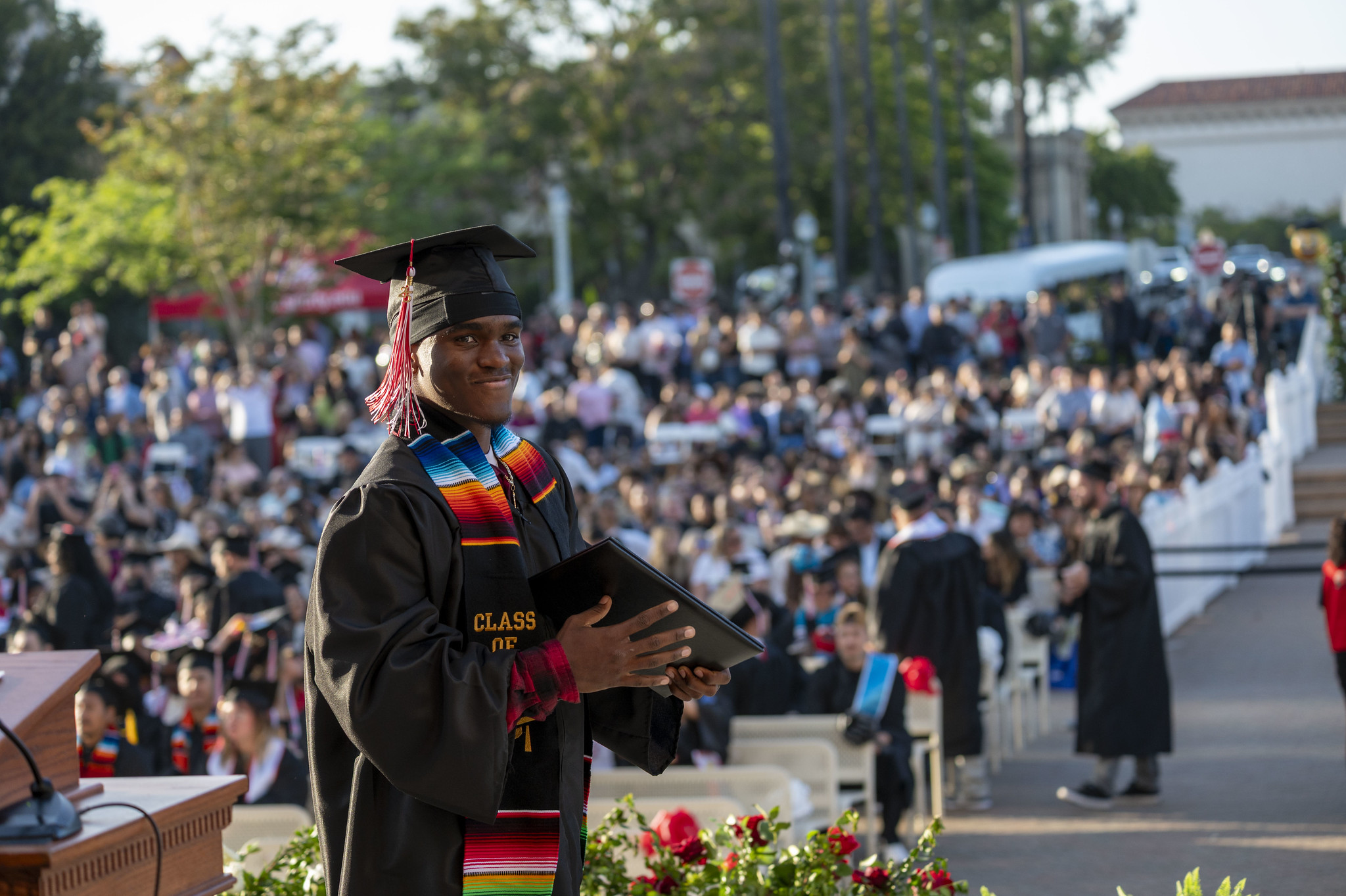
A graduate smiling as he walks across the stage after receiving his diploma.
