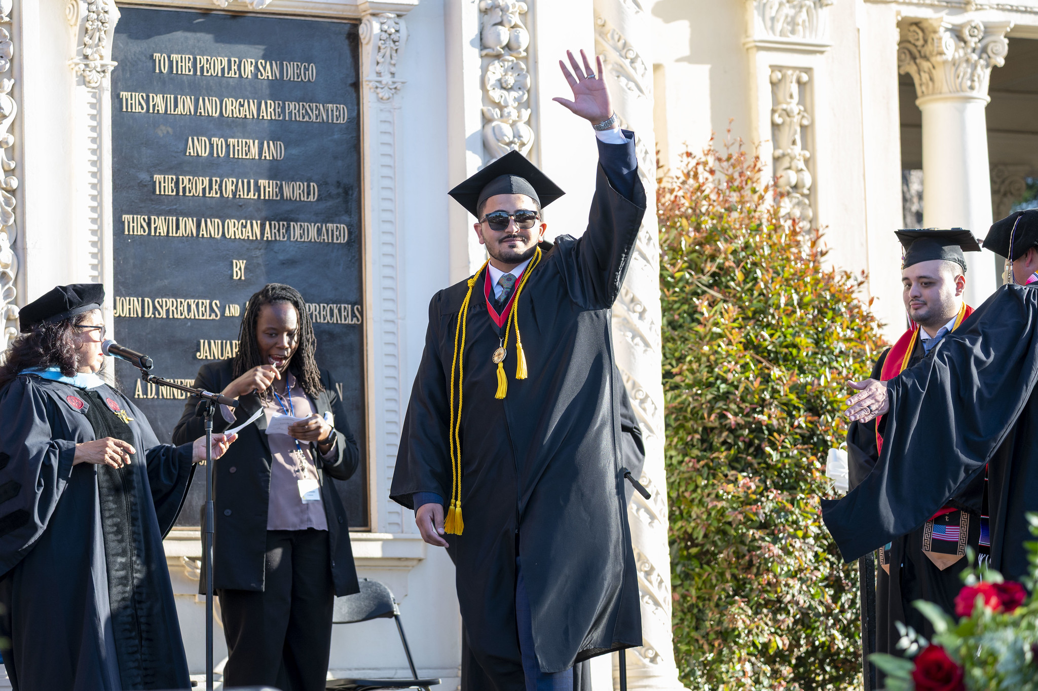 
A graduate waves to the audience as his name is read out.
