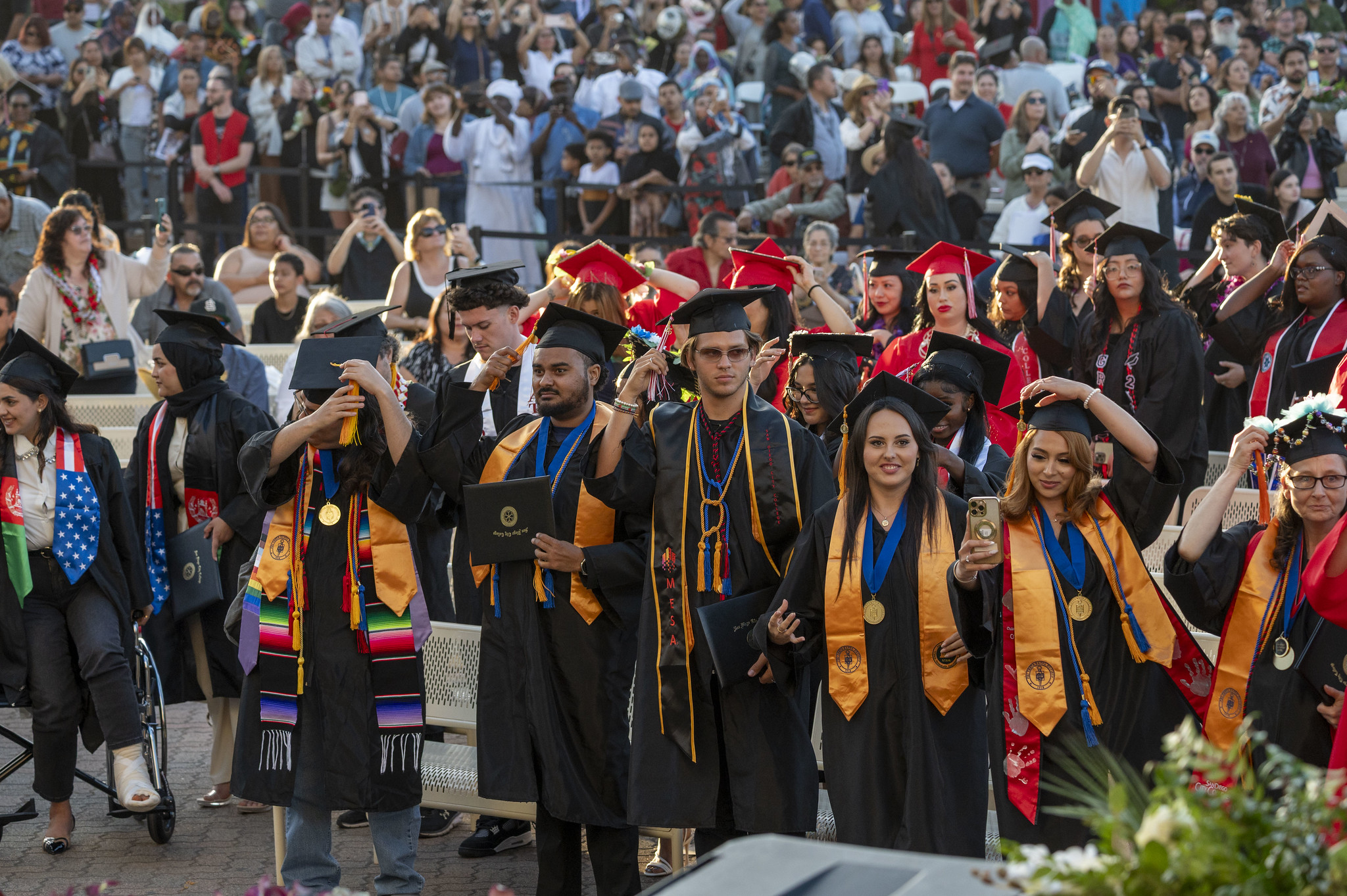 
Graduates in the audience turn the tassles on their caps.
