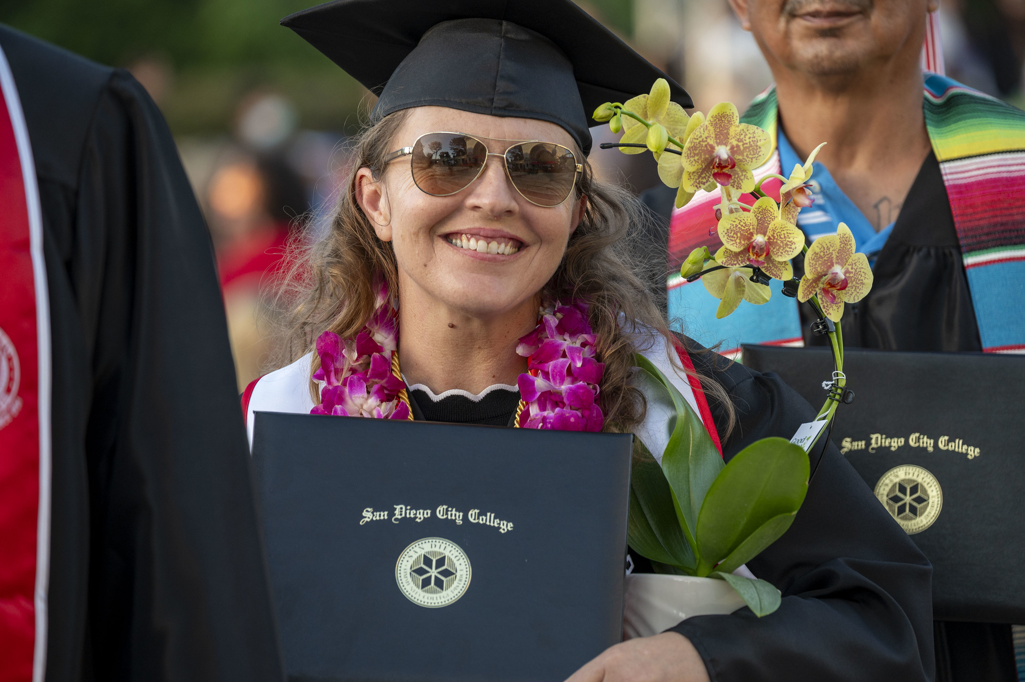 
A graduate holds up her degree.
