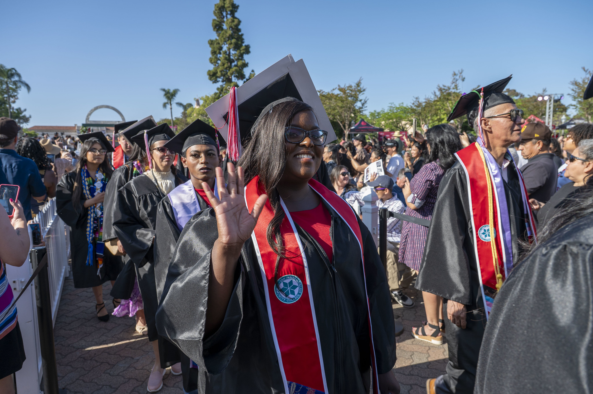 
A grad waves as she lines up to enter at the beginning the ceremony.
