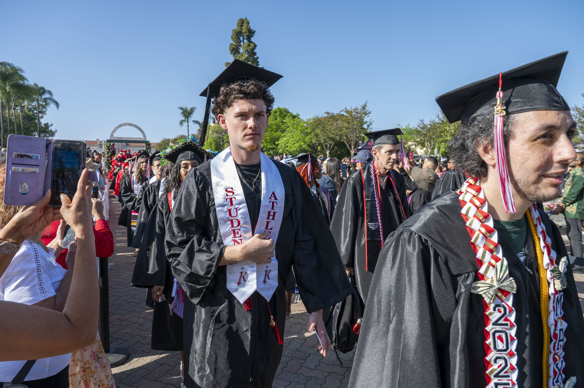 
A graduate with a student athlete sash enters the commencement ceremony.
