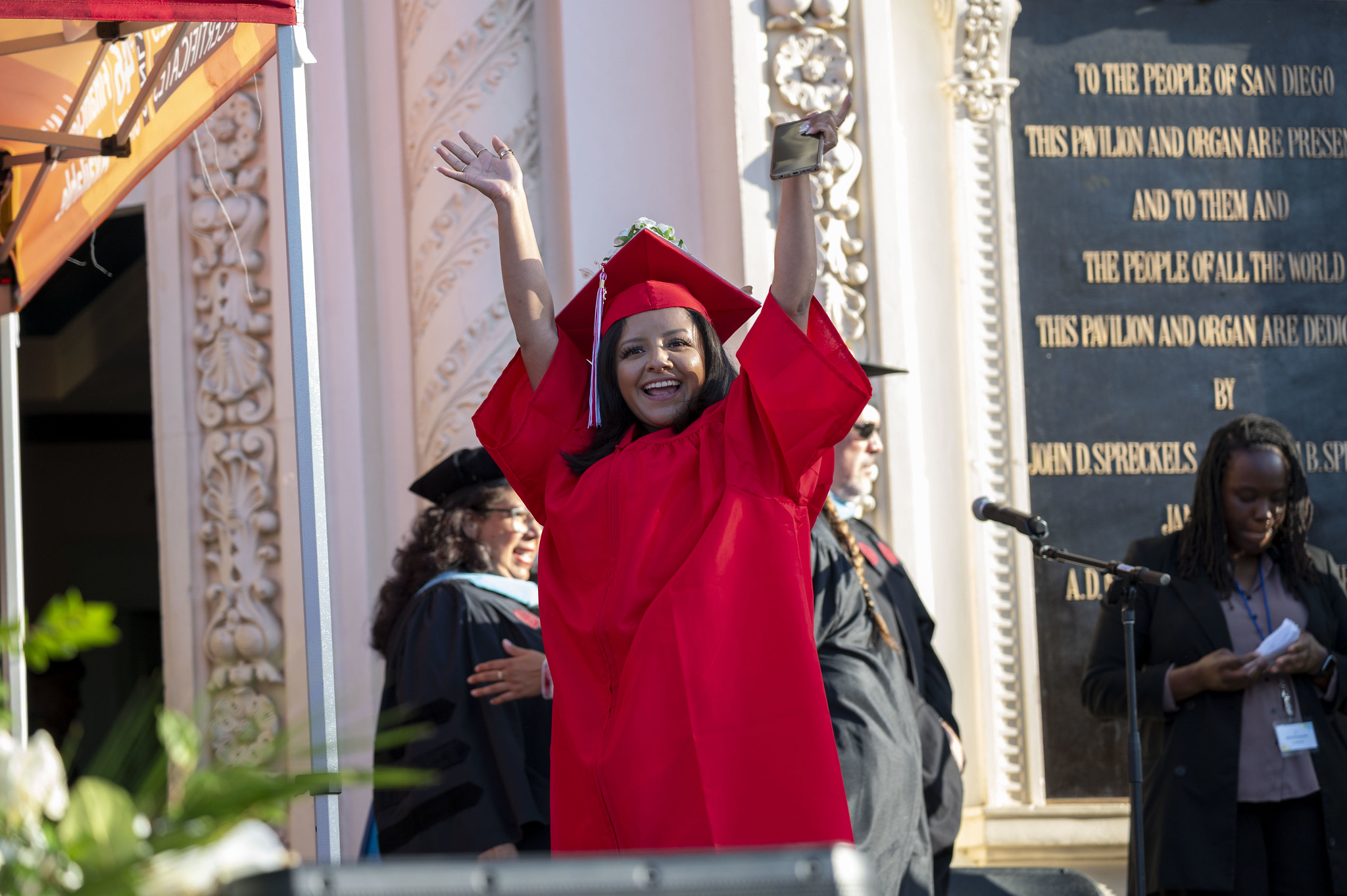 
A graduate cheers as she crosses the stage.
