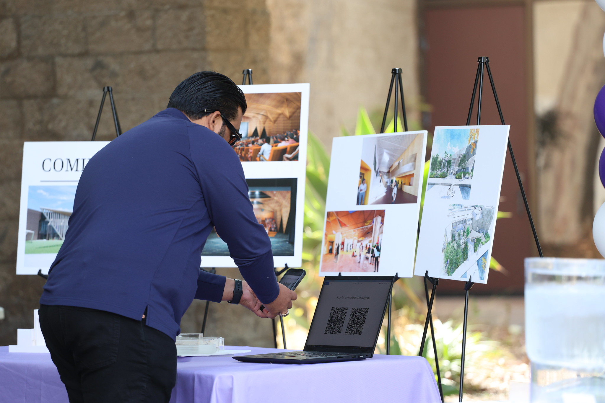
A man at a table displaying renderings of the renovation.

