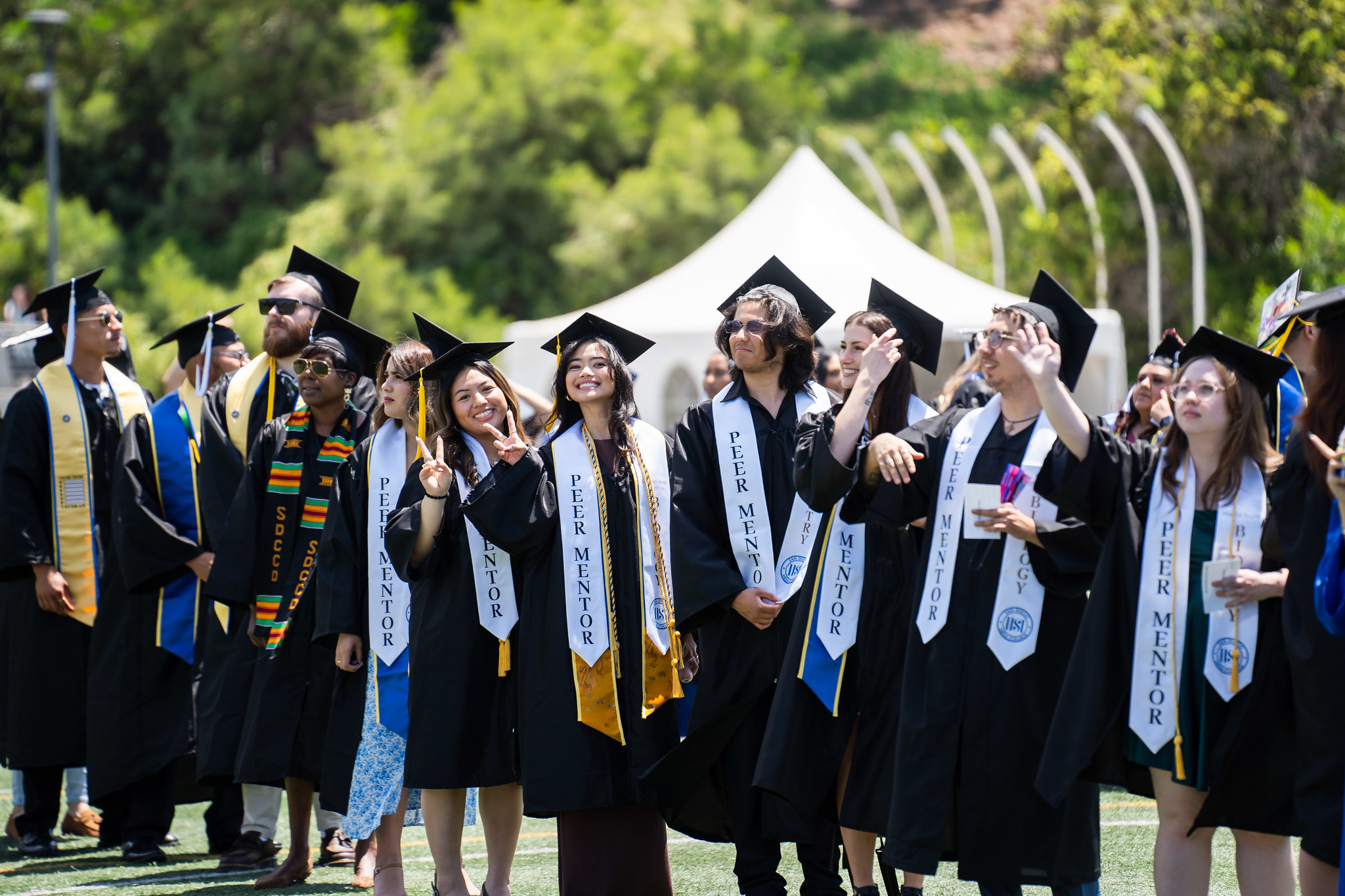 
Six graduates line up for a group photo on the field at commencement.
