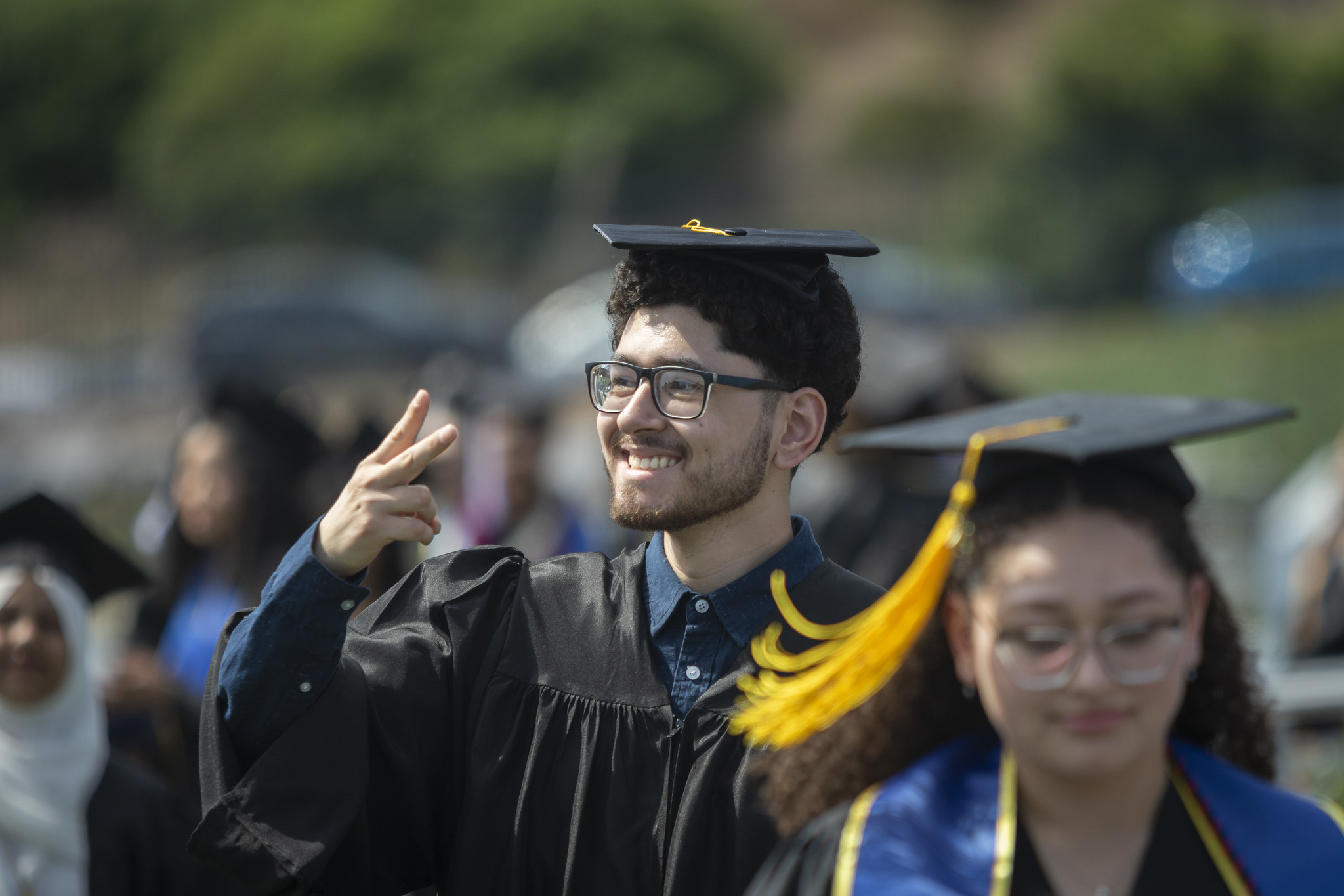 
A graduated gives a peace sign.
