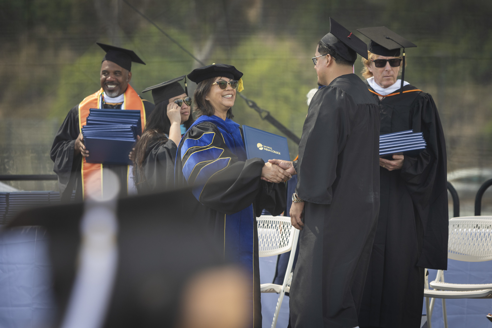 
Trustee Marichu Magaña hands a graduate a diploma.
