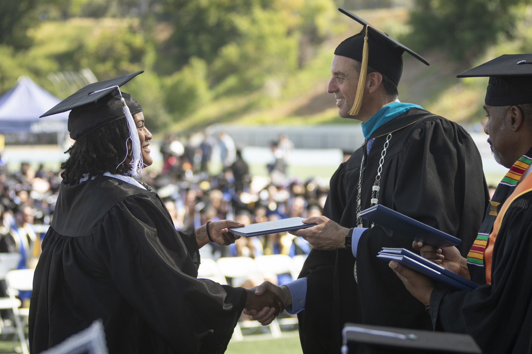 
Chancellor Gregory Smith hands a graduate her diploma./p>
