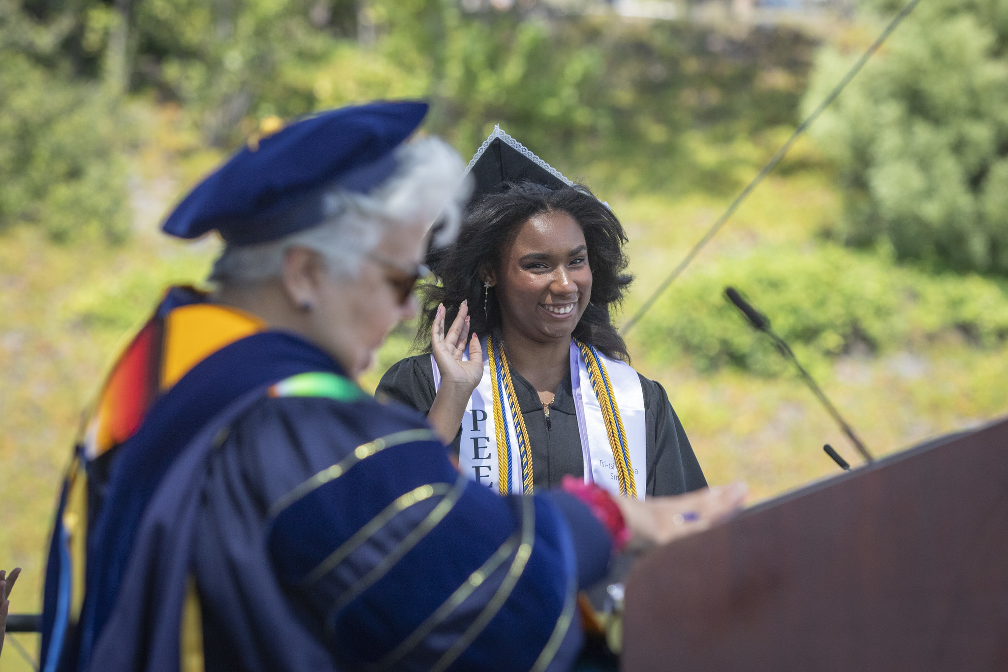 
A student waves as she crosses the stage to receive her diploma.
