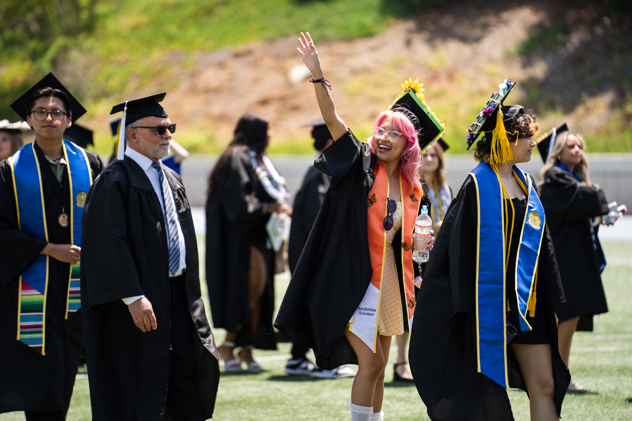 
A graduate waves to the crowd as she heads to her seat.
