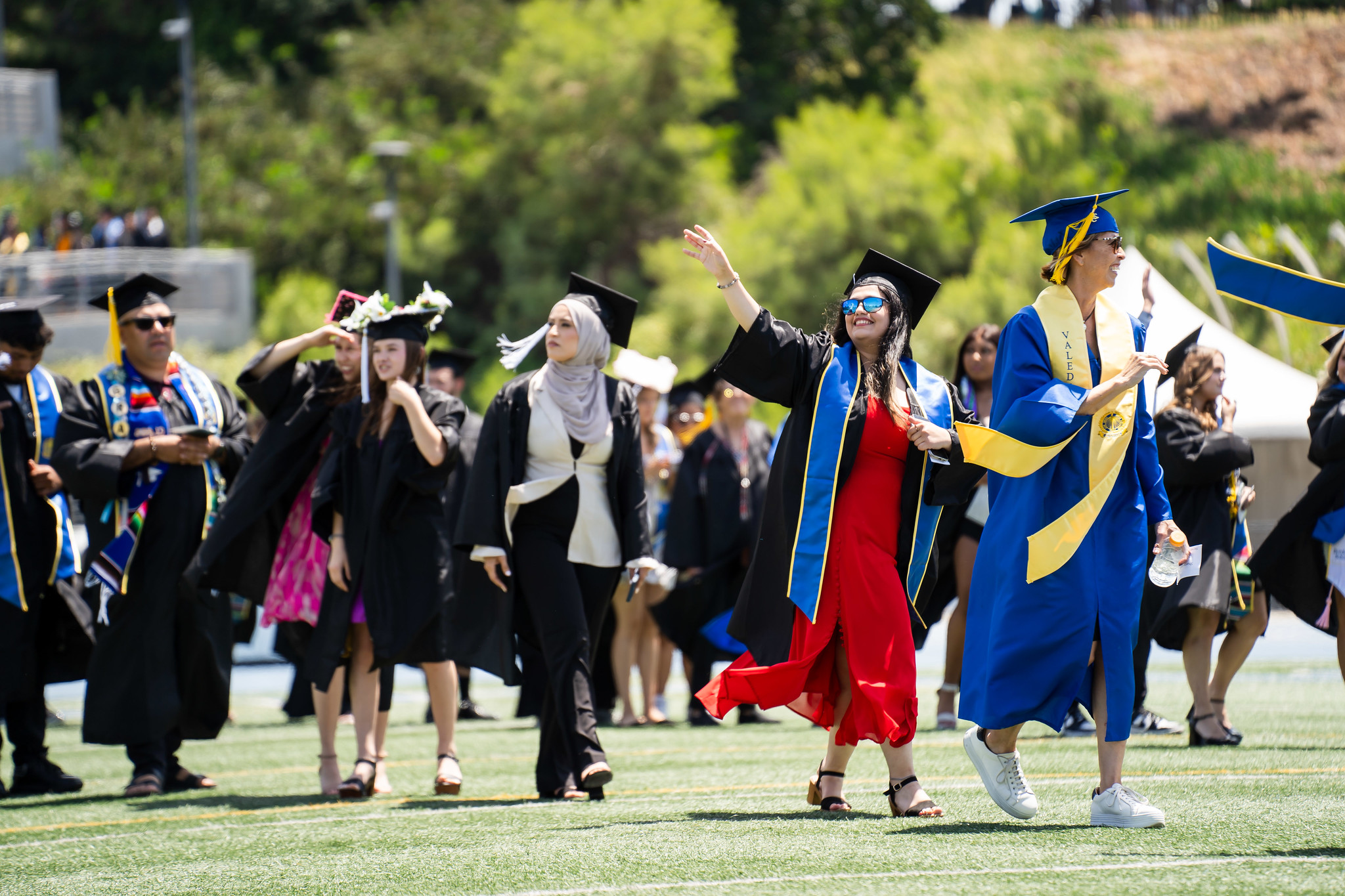 
A graduate waves to the crowd at she heads to her seat.
