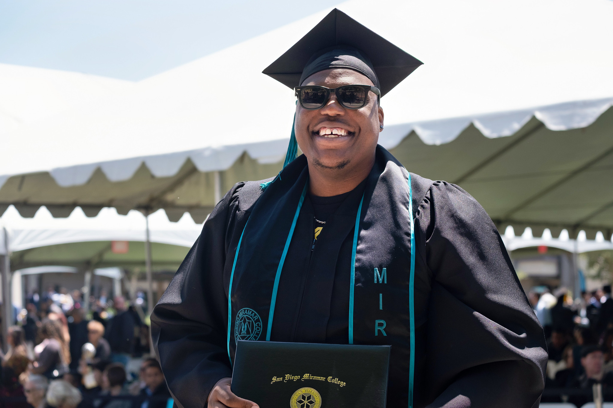
A student holds up his degree.
