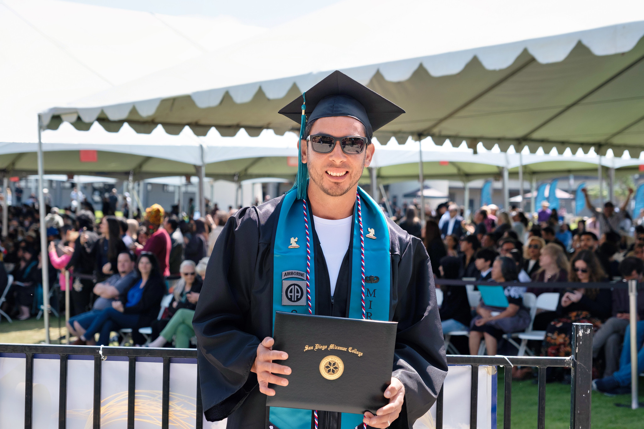 
A student holds up his degree.
