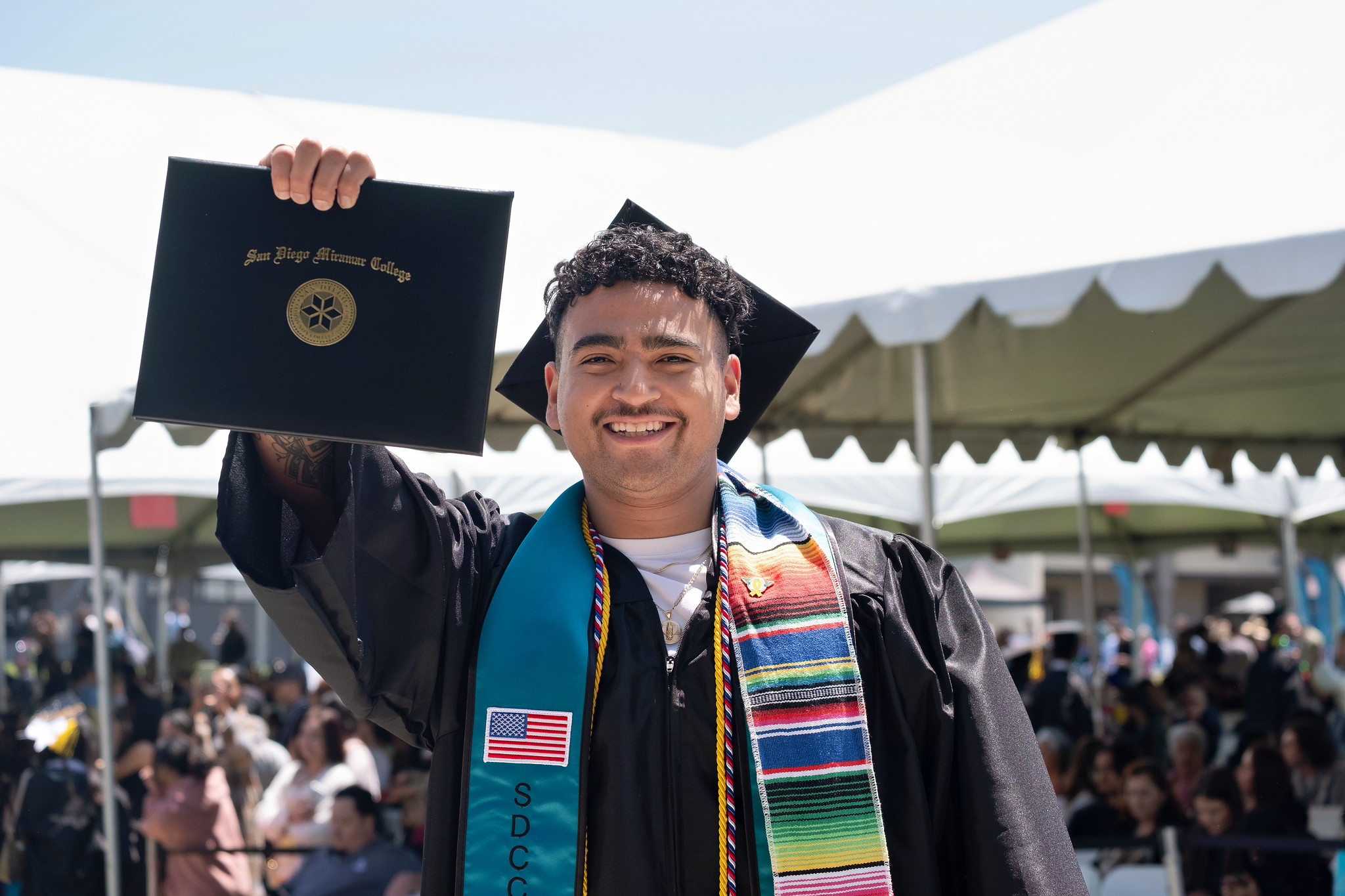 
A graduate is holding up his degree.

