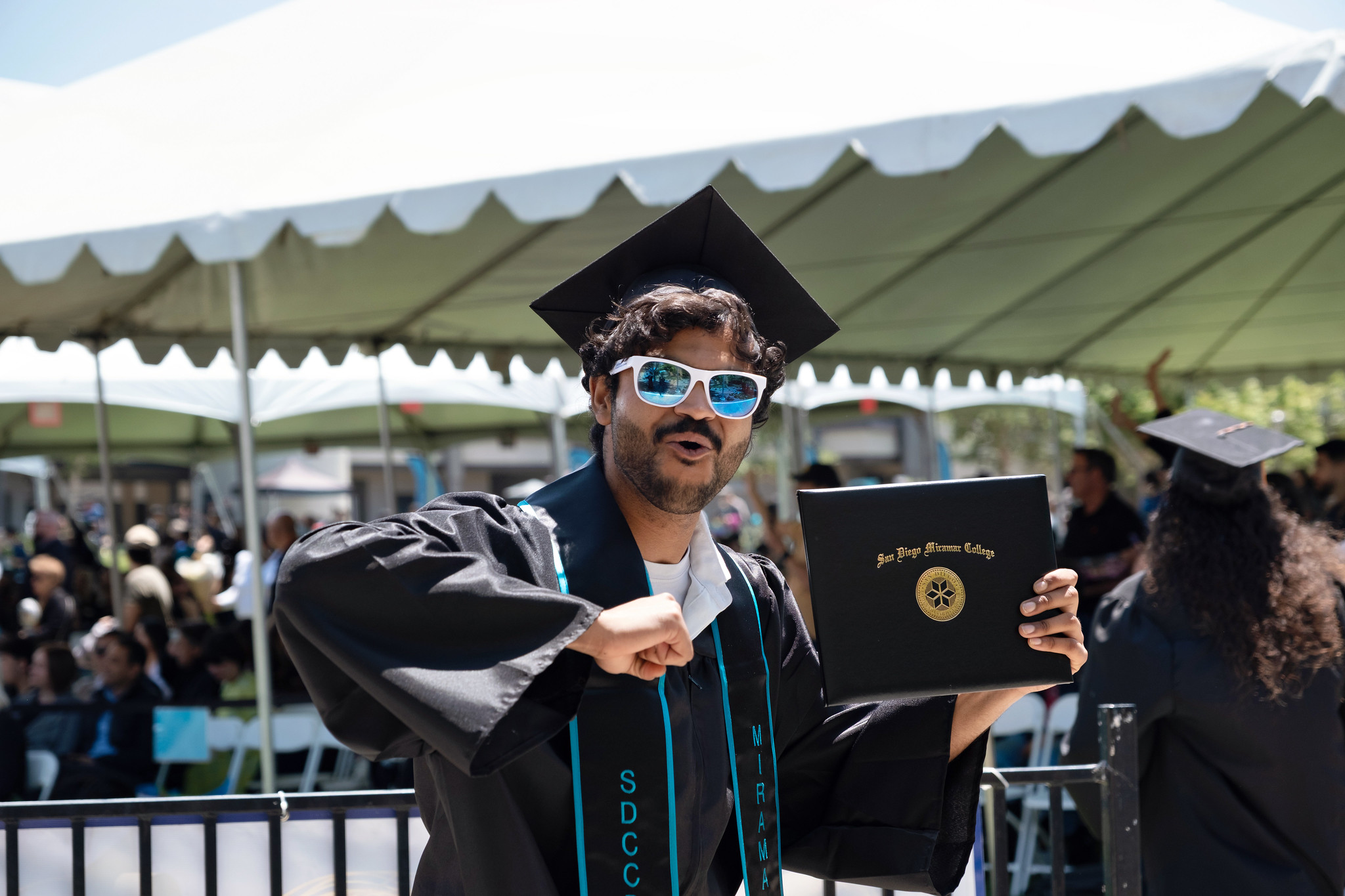 
A student holds up his degree.
