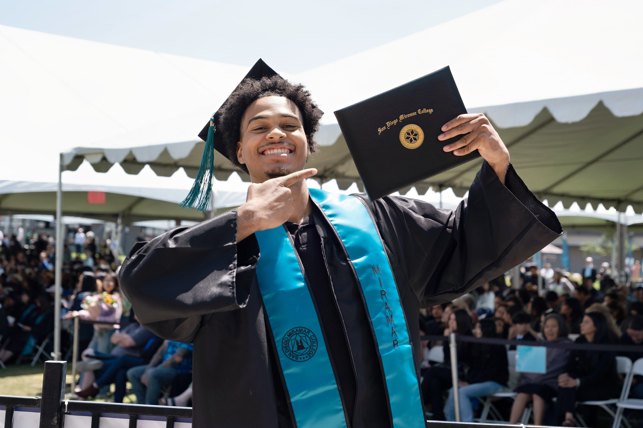 
A graduate holds up his degree.
