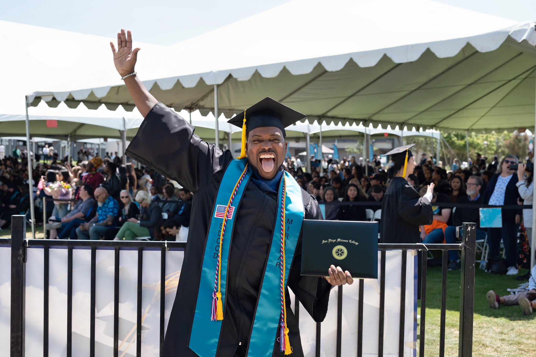 
A graduate holds up his degree.
