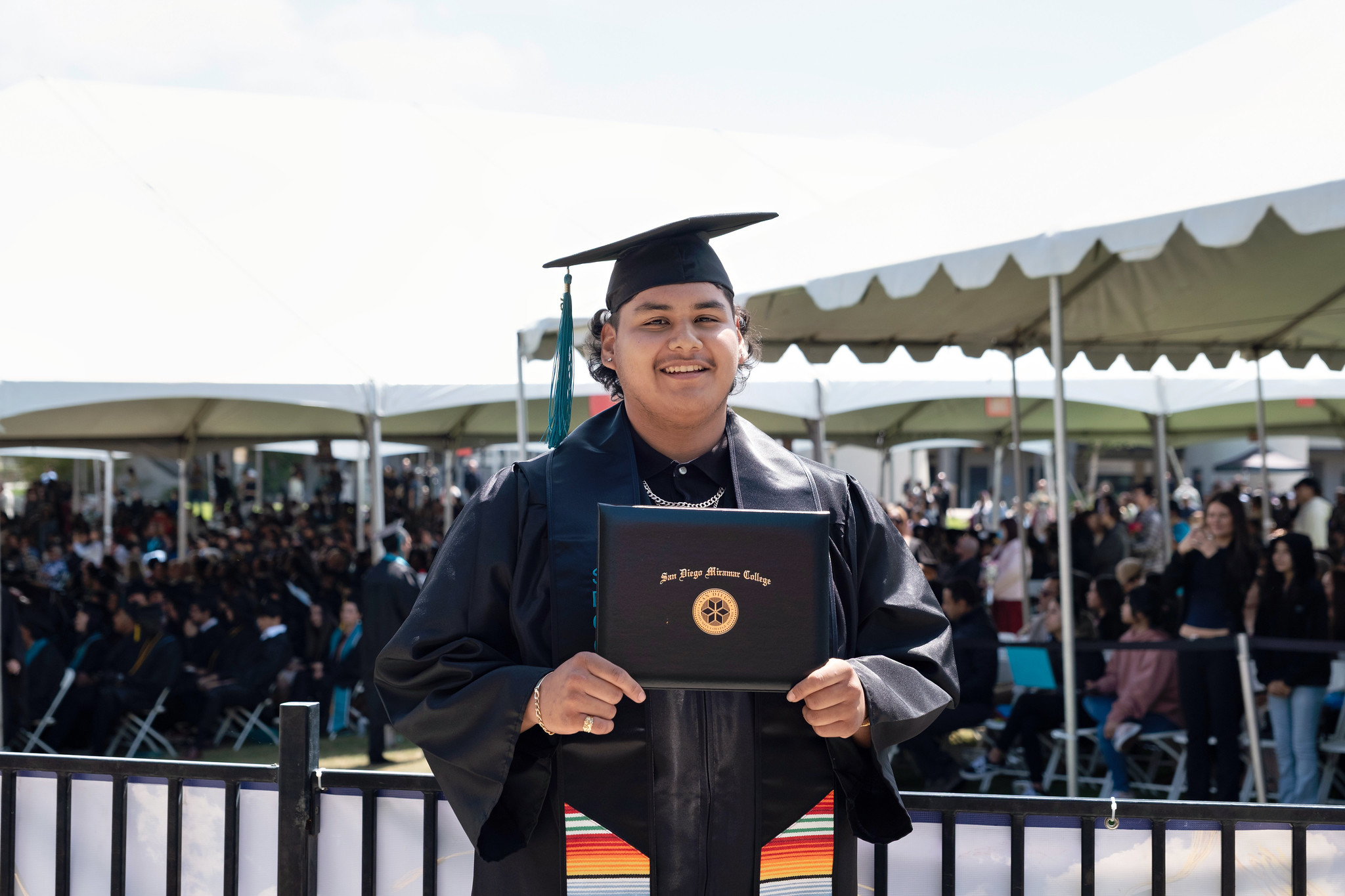 
A graduate holds up his degree.
