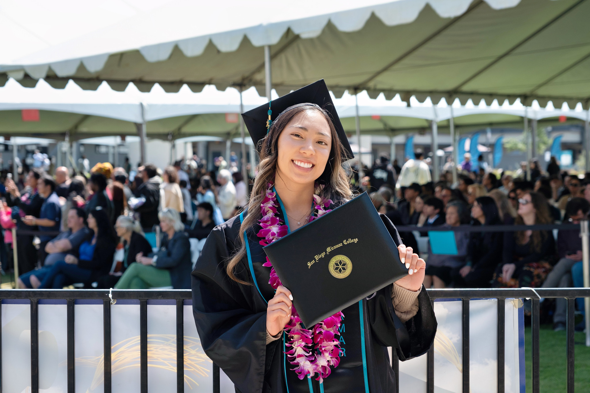 
A graduate holds up her degree.
