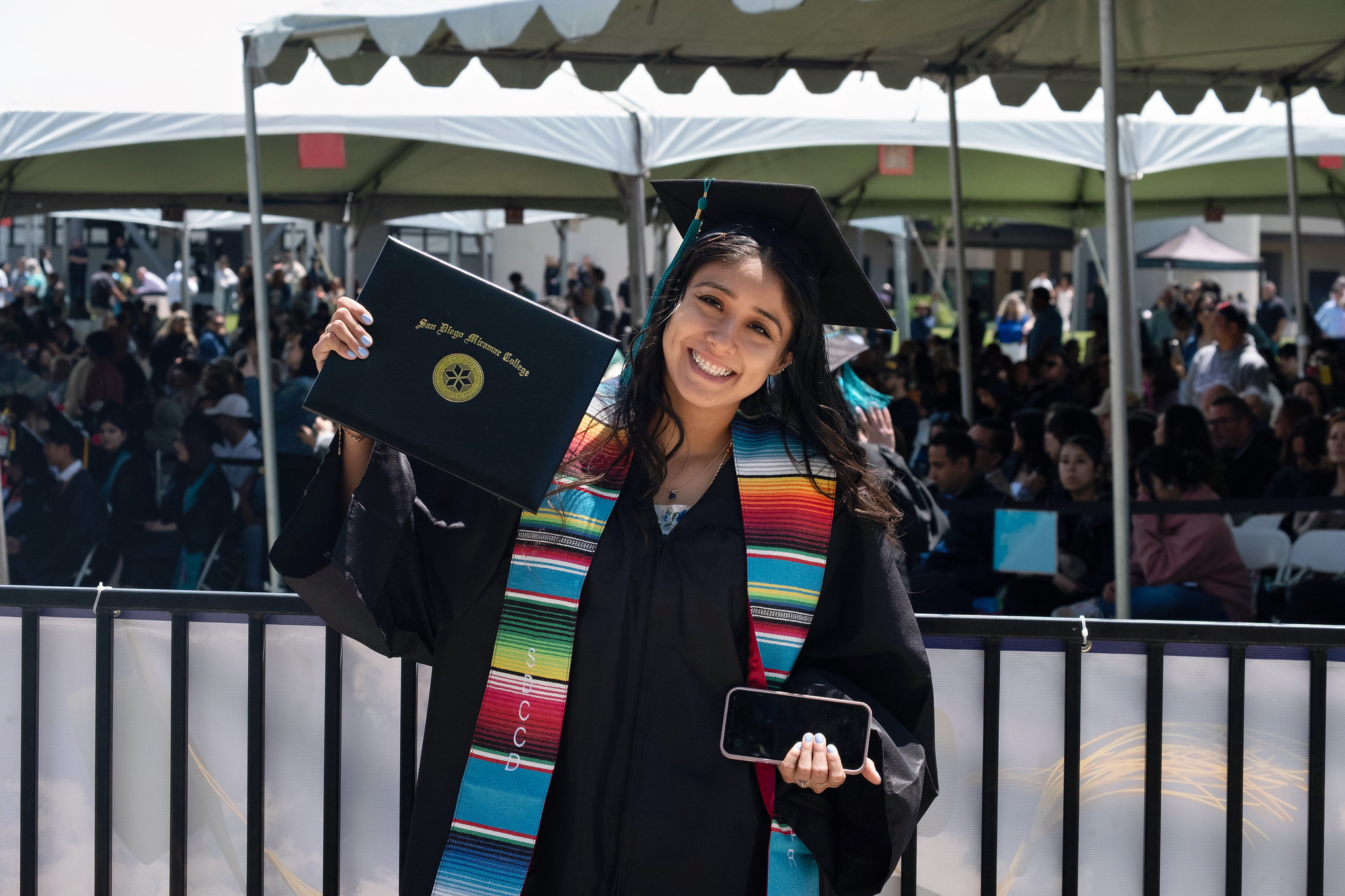 
A graduate holds up her degree.
