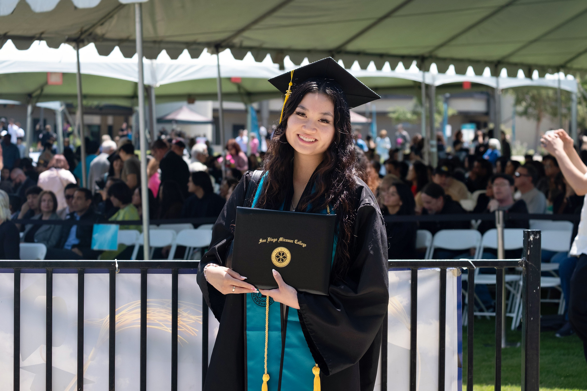 
A graduate holds up her degree.

