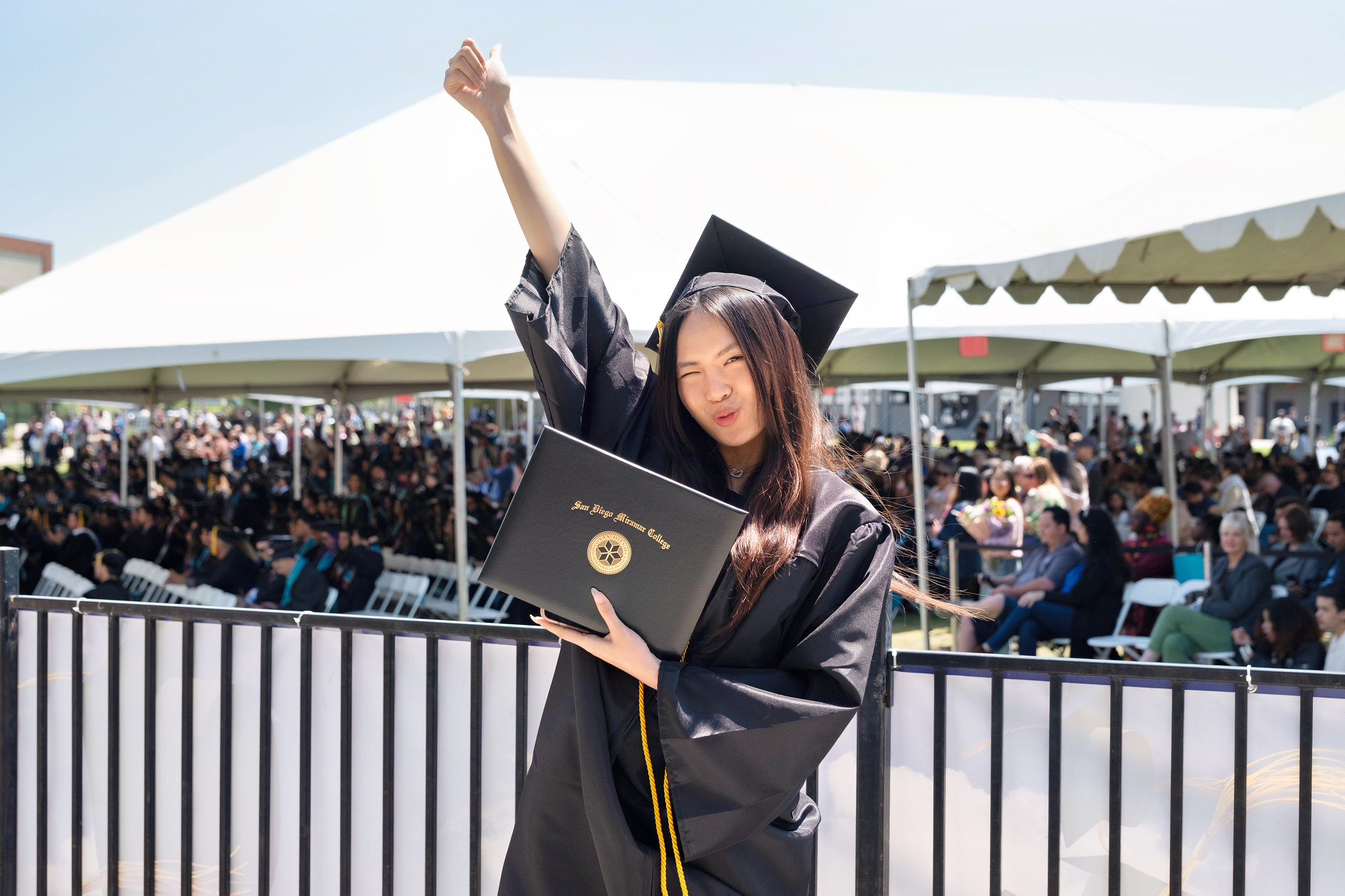
A graduate holds up her degree.

