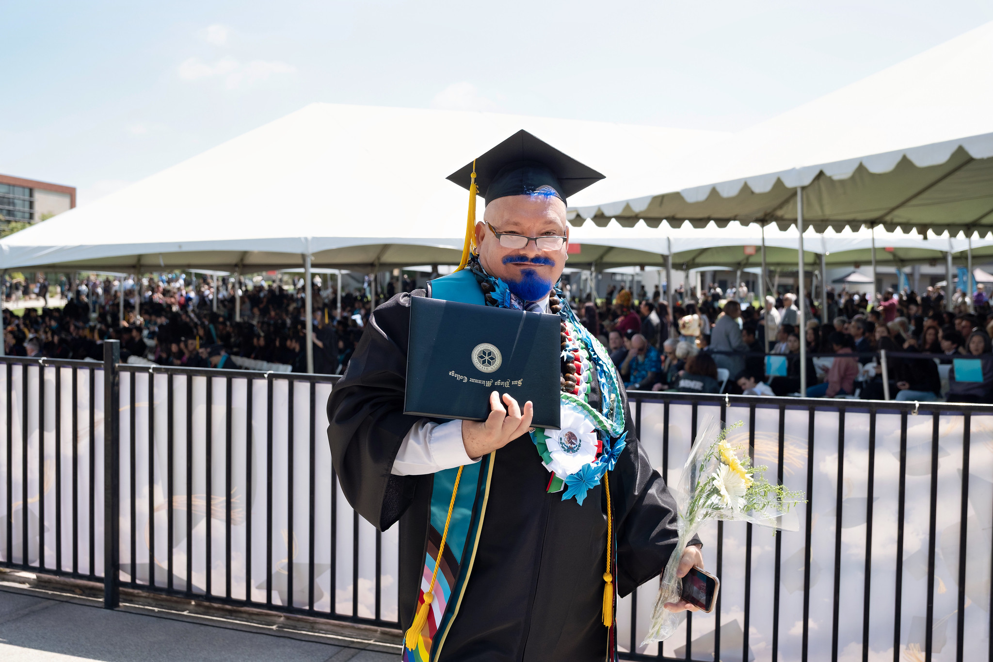
A graduate holds up his degree.
