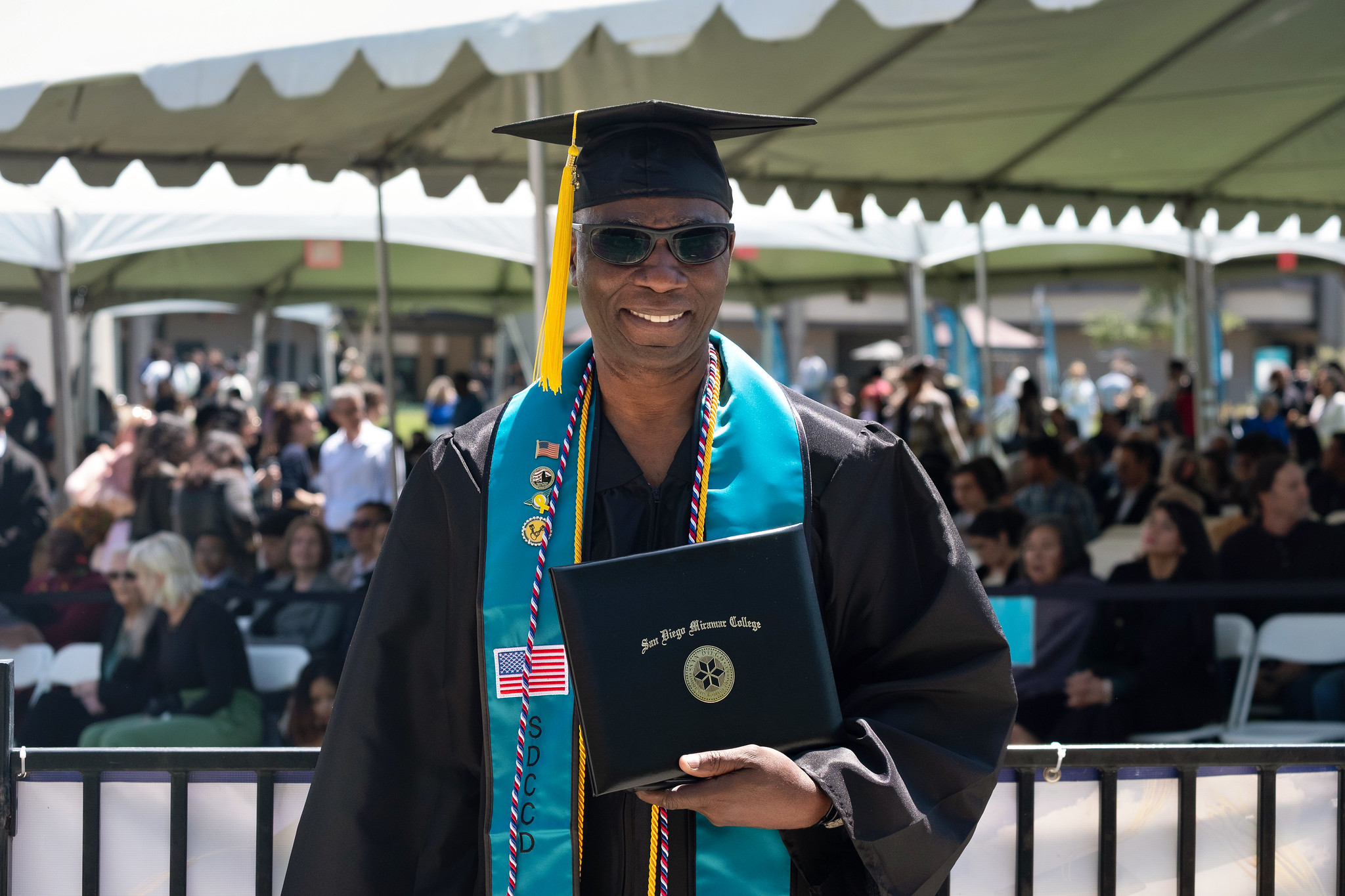 
A graduate holds up his degree.

