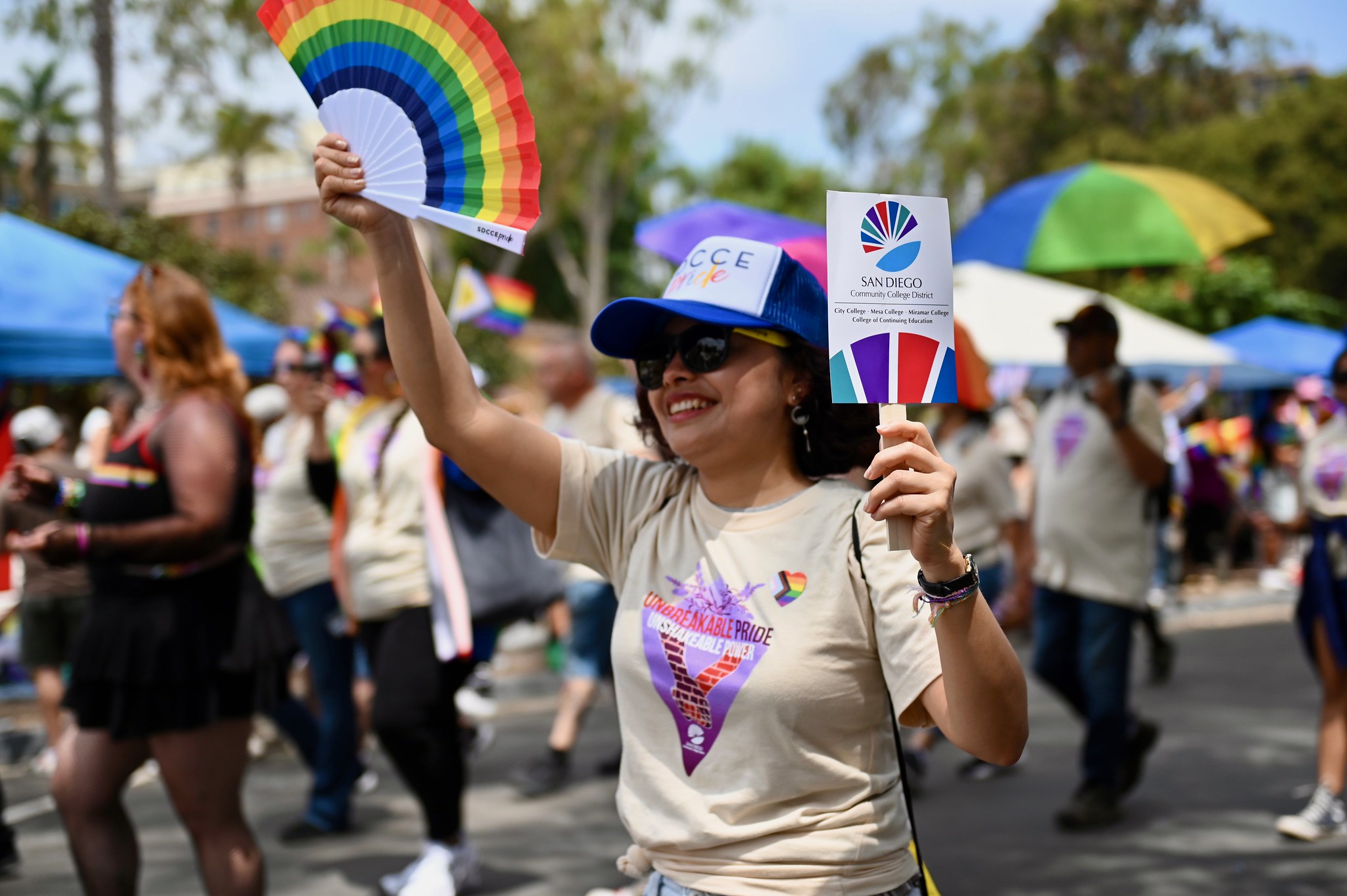 
A lady with a rainbow fan walks in the Pride Parade.
