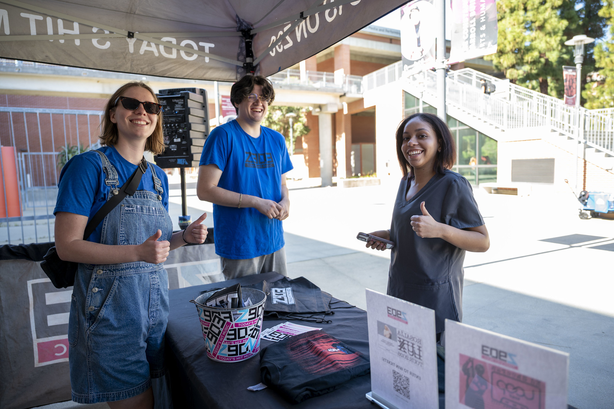 
Three people at a City College welcome tent.
