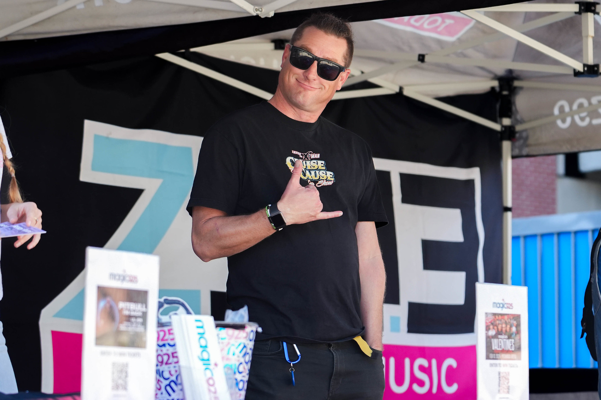 
A man working a City College welcome booth gives a hang loose sign.
