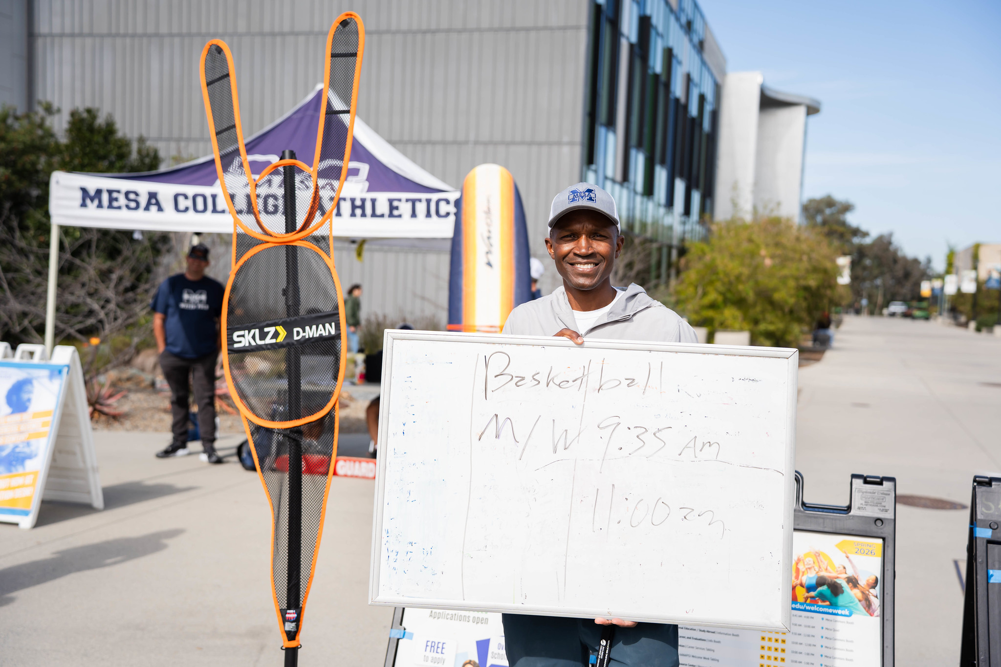 
A coach holds up a white board promoting Mesa football.
